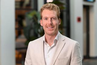 a man in a white suit with a purple background